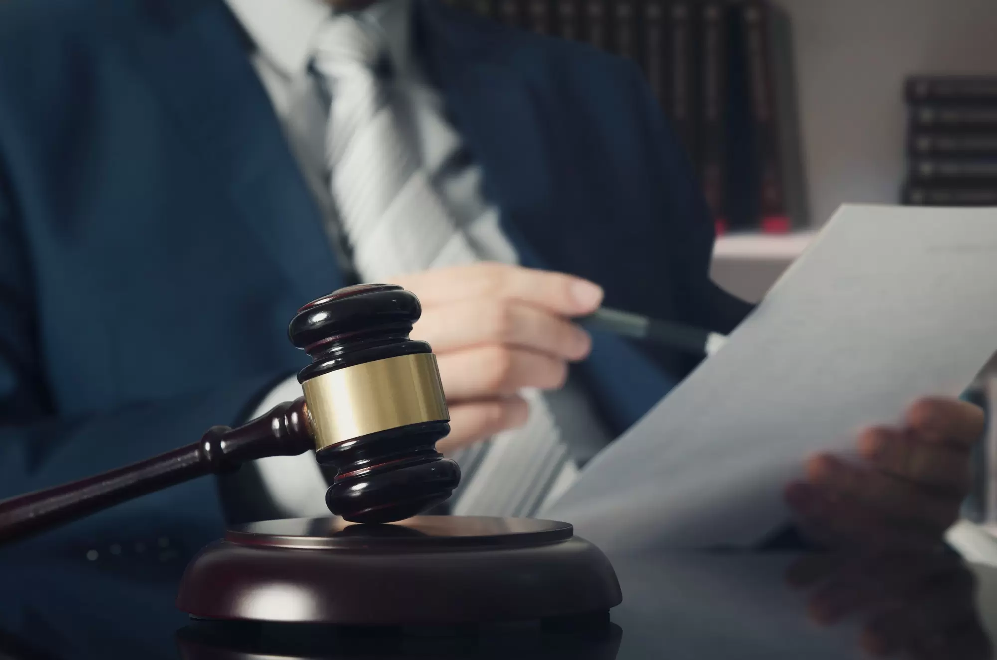 Wooden gavel, working lawyer in background. lawyer law justice judge gavel courtroom legal table concept