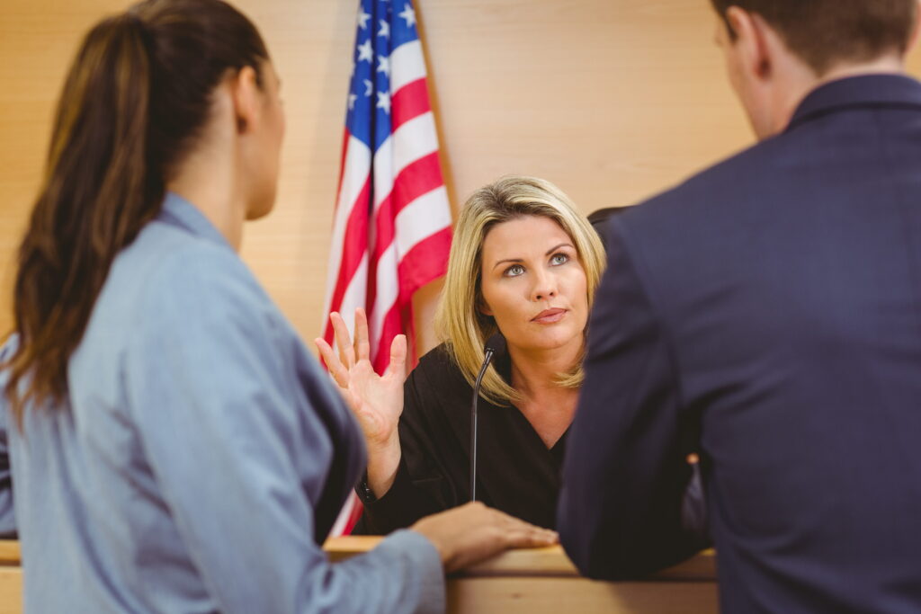 Judge and lawyers speaking in front of the american flag in the court room